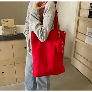 Red canvas tote bag with cartoon monster embroidery and matching small coin purse detail