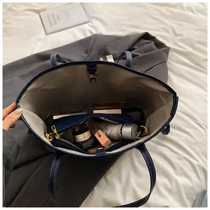 Vue détaillée du grand sac cabas en denim bleu marine avec coutures contrastées et pochette