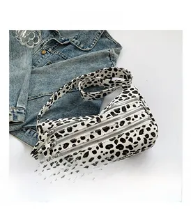 Détail des compartiments zippés multicouches sur un sac bandoulière à imprimé léopard