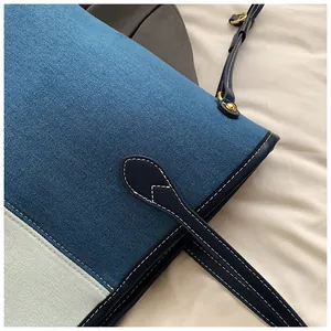 Détails du sac fourre-tout en denim avec coutures contrastées et boucle dorée