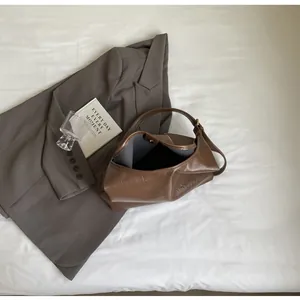 Gros plan du sac cabas marron à texture vintage, fermoir magnétique et large bandoulière