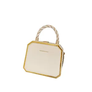 Sac à main octogonal blanc crème avec cadre en métal doré et poignée torsadée