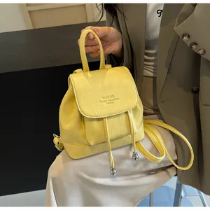Close-up of bright yellow leather mini backpack with drawstring and magnetic closure
