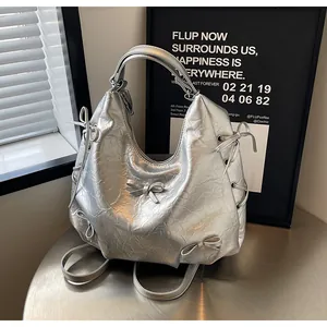 Detail of silver tote bag featuring metallic crinkled fabric and 3D bow accents