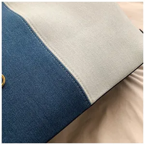 Gros plan détaillé du sac cabas en denim avec surpiqûres et finitions métalliques dorées