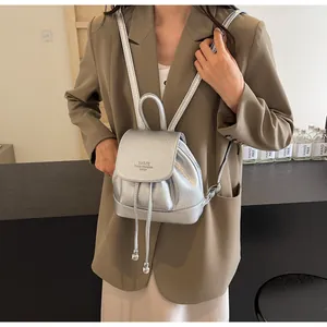 Mini silver metallic backpack made of textured faux leather with drawstring and top handle