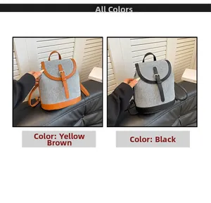 Detail view of mini backpacks in grey fabric with yellow-brown and black leather trim