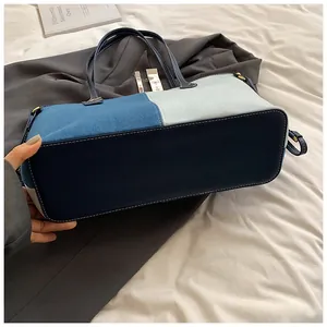 Vue détaillée du sac en jean avec patchwork tricolore et surpiqûres blanches contrastées