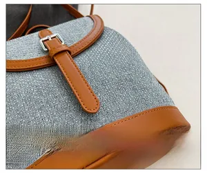 Close-up of blue-grey tweed texture with clear crystal accents and brown leather strap