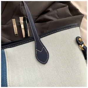 Détail du cabas en jean avec bordure en cuir bleu et coutures blanches contrastées
