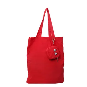 Red canvas tote bag set with embroidered cartoon eyes and matching small pouch
