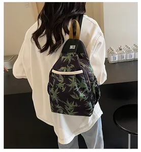 Detail of green bamboo leaf print on a black shoulder bag with metal twist lock