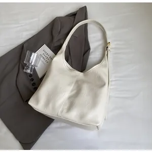 Détail du sac cabas crème avec texture plissée et boucle de réglage dorée élégante
