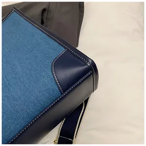 Detailed macro shot of denim and leather stitching on trendy commuter handbag