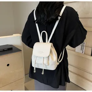 Detailed back view of a white mini leather backpack with drawstring and silver bead charms