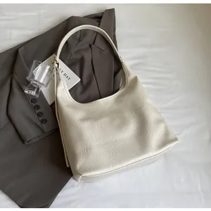 Détail du sac à main blanc cassé avec texture froissée et élégante forme de demi-lune