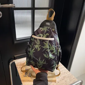 Detail of bamboo leaf print crossbody bag with silver twist lock and woven strap