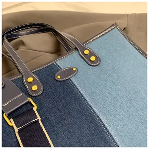 Detailed shot of two-tone denim tote bag featuring contrast stitching and leather trim