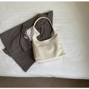 Détail du sac fourre-tout ivoire avec texture froissée et bandoulière réglable design