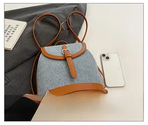 Detail showing woven grey texture and brown leather trim on this stylish backpack