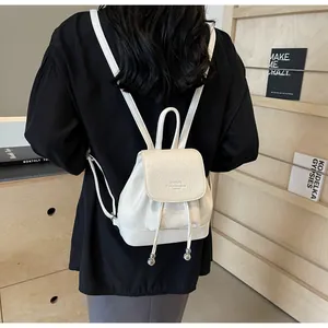 White faux leather mini backpack with pebble texture and drawstring closure detail