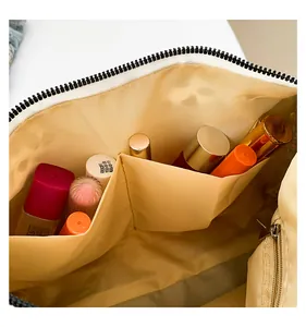 Détail intérieur du grand sac léopard avec doublure champagne et poches de rangement