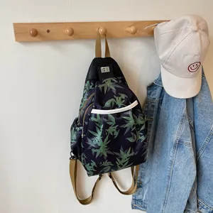 Detail of bamboo leaf print crossbody bag with silver metal twist lock and blue fabric