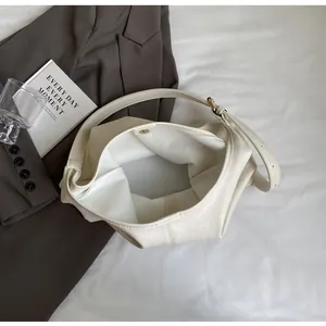 Détail du sac cabas en cuir blanc cassé avec fermoir magnétique et texture grainée
