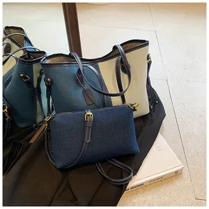 Détail d'un grand cabas en jean avec patchwork en cuir crème et petit sac bandoulière assorti