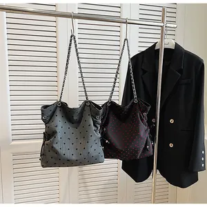 Detail of canvas bucket bags with chain straps in polka dot and heart patterns