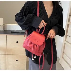 Detail of red faux leather mini backpack with drawstring and silver bead accents