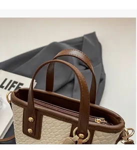 Detail of woven tote bag with brown leather handles and premium gold metal rings