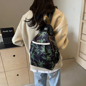 Detail of bamboo leaf print backpack with leather trim and metal clasp on model