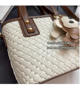 Detail of cream woven leather texture with brown strap and cute bear charm pendant