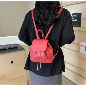 Detail of red faux leather mini backpack featuring lychee texture and drawstring closure