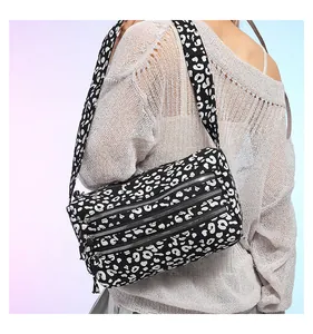 Détail d'un sac cabas léopard avec trois poches zippées et bandoulière assortie à l'épaule