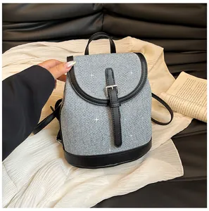 Detail of glittery grey tweed backpack with black leather trims and silver buckle
