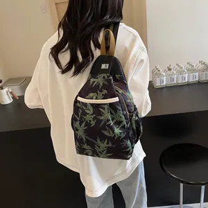 Detail of bamboo leaf print crossbody bag with metal rotary lock and webbing handle