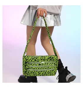Détail du cabas léopard vert fluo avec plusieurs poches zippées sur le devant