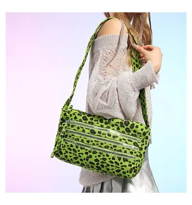 Détail du sac léopard vert néon avec trois fermetures éclair argentées sur le devant