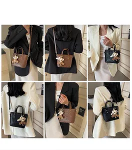 Detail of woven texture tote bag with a cute monkey charm in black and brown colors