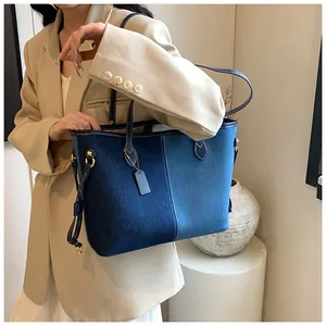 Détails d'un cabas en denim bicolore avec finitions dorées et cordons latéraux