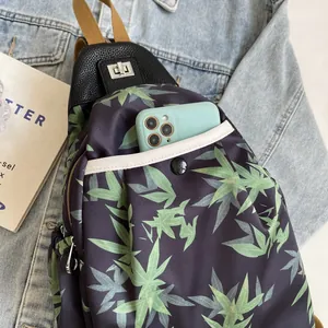 Detail of bamboo leaf print crossbody bag with silver twist lock and front phone pocket