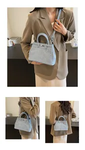 Detailweergaven van lichtblauwe denim draagtas met metalen sluiting en schouderband