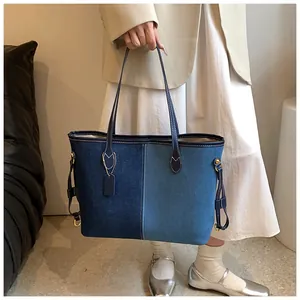 Détail d'un grand sac cabas en denim avec un design patchwork bleu élégant et poignées