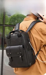 Detail of vintage black PU leather backpack with external USB charging port in use
