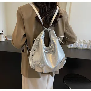 Detail of metallic silver pleated backpack featuring chic 3D bow and drawstring accents
