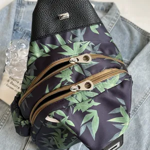 Detail of bamboo leaf print fabric and dual zipper design on a triangle crossbody bag