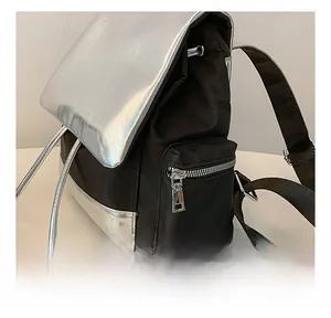 Close-up of smooth metal zipper and silver mirror leather detail on contrast backpack