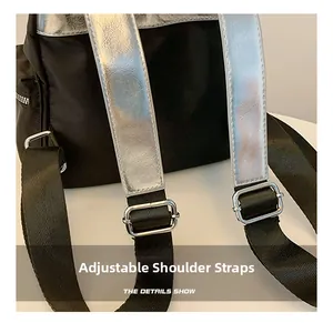 Close-up of adjustable shoulder straps with silver metal buckles on a black backpack